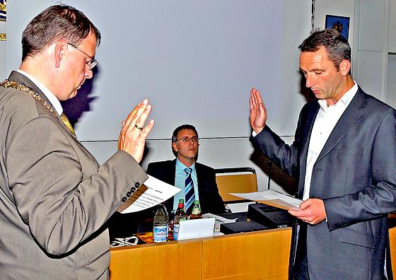 Bürgermeister Wolfgang Panzer (l.) vereidigt Jürgen Köster (SPD) als Gemeinderatsmitglied. 	Foto: Kohnke