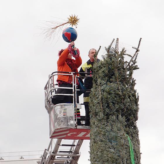 Anbringen der Christbaumspitze,  gefertigt von der Frauenkunstwerkstatt von LebensArt e.V. Foto: VA