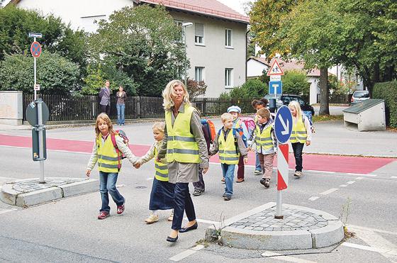So ist es richtig: Eine Mutter übt den Schulweg mit den Kindern  und alle tragen die ADAC Sicherheitsweste.	Foto: ADAC Südbayern