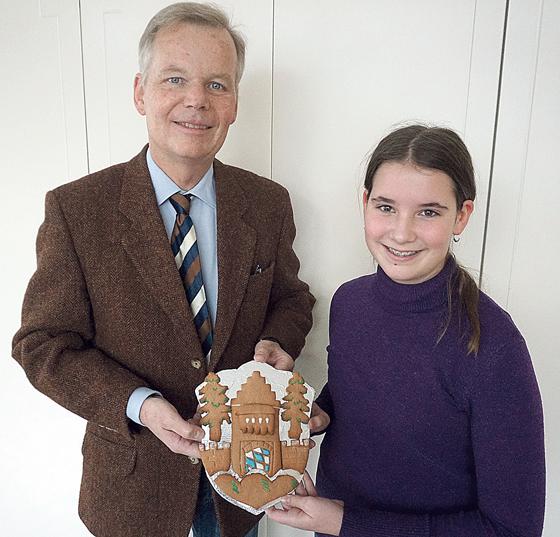 Grünwalds Bürgermeister Jan Neusiedl bedankte sich herzlich bei Anja Stutz (13 Jahre), die ihm ein selbstgebackenes Gemeindewappen überreichte. 	Foto: Gemeinde