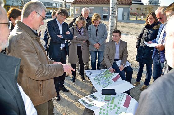 Poings Bürgermeister Albert Hingerl (Zweiter von links) begutachtet die Pläne für die Ortsmitte, die Architekt Max Bauer (links) vorstellte.	Foto: ARGE Poing »Am Bergfeld«