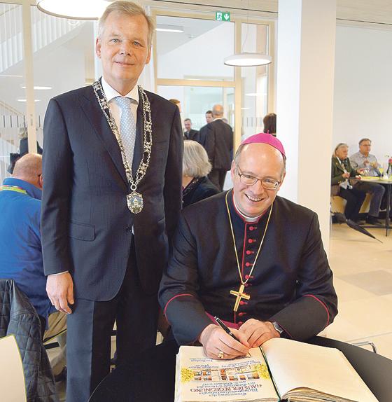 Bürgermeister Jan Neusiedl freute sich, dass sich Weihbischof Rupert Graf zu Stoberg ins Goldene Buch eintrug. 	Foto: hw