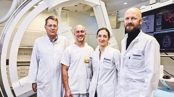 Prof. Claus Zimmer (links) mit Mitarbeitern vor der Angiographie-Anlage. 	Foto: MRI/TUM