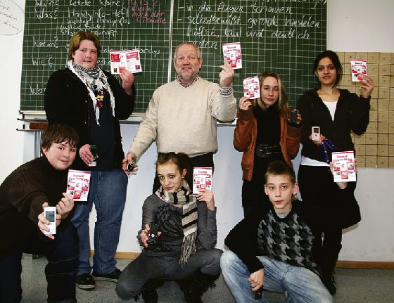 »Erst lesen, dann Handy einschalten«  Rektor Clemens Hauck ist stolz auf die Broschüre seiner Schüler, die ihm einige Achtklässler gezeigt haben.	 Foto: em