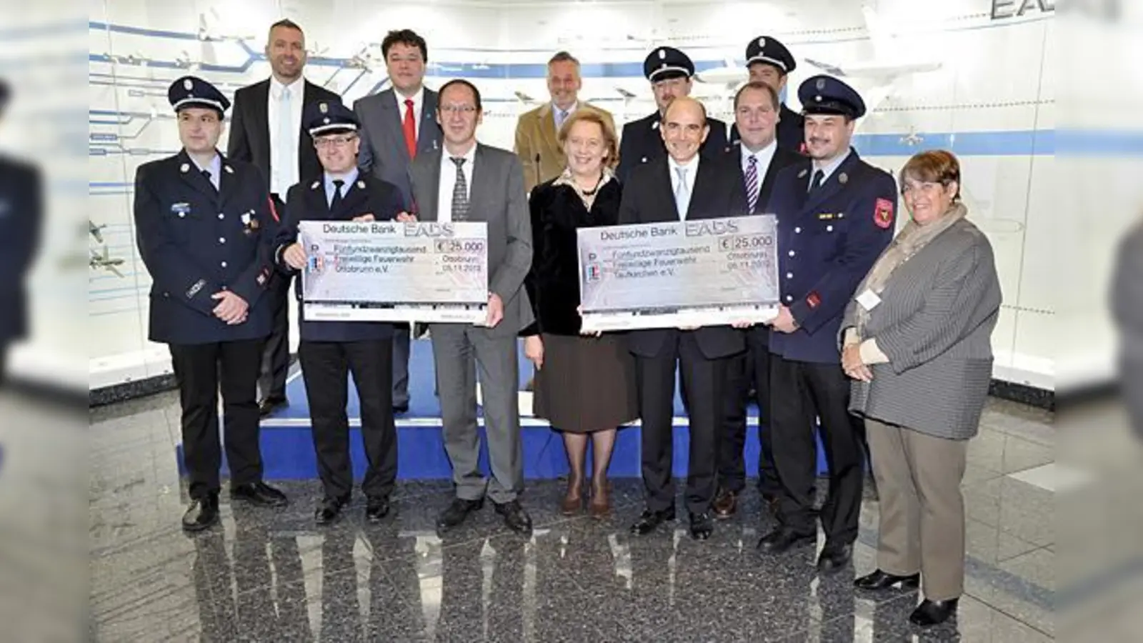 Spendenübergabe bei der EADS: Vorstand Klaus Ortmeier und ­Rudolf Henneberger von Astrium (3. und 5. v.l.) mit dem Spendenscheck für die Ottobrunner Feuerwehr. 	 (Foto: EADS)