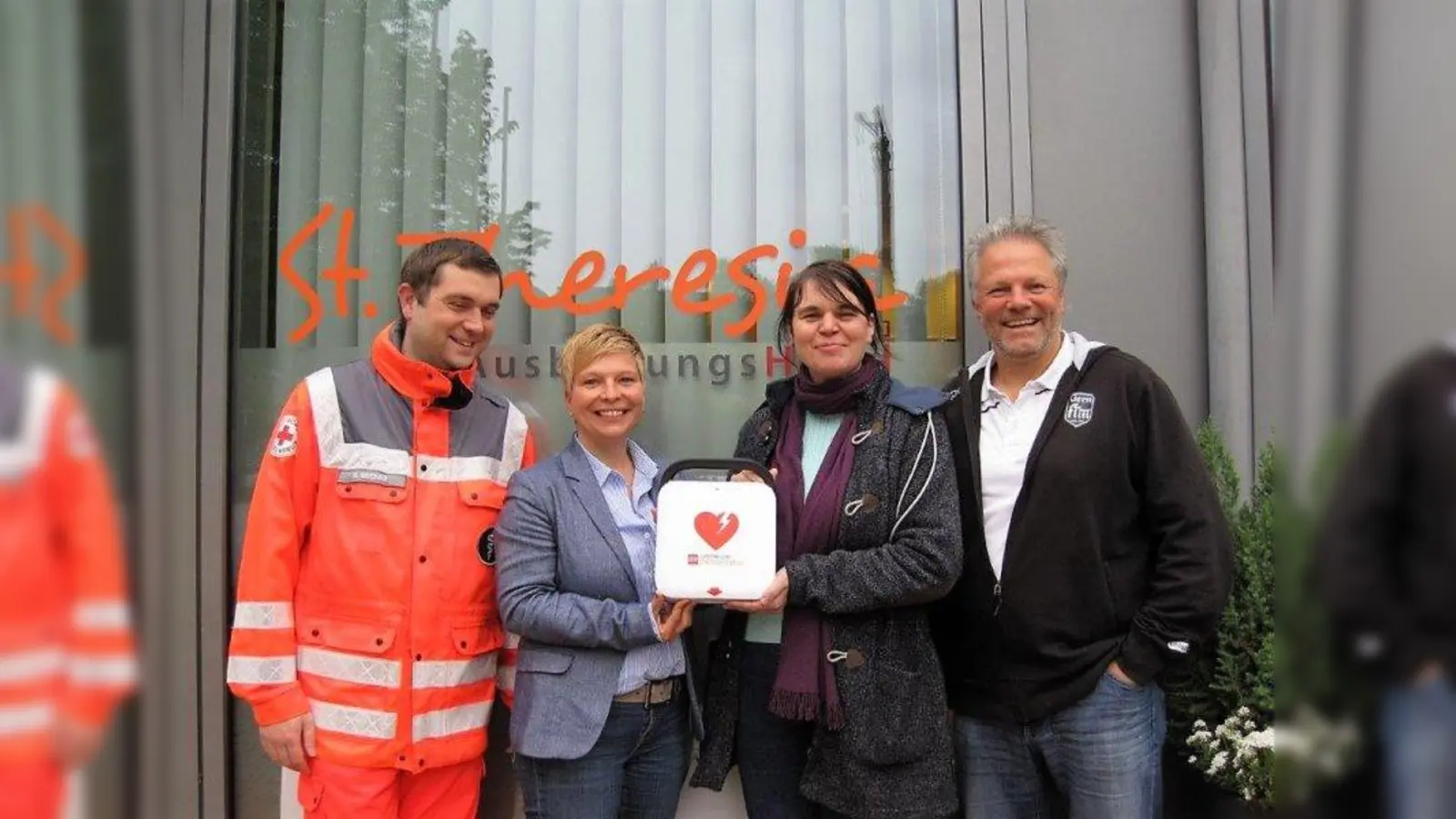 Freuen sich über den Defibrilator, der nun in der Hanebergstraße für alle zugänglich ist (von links): Michael Greiner (BRK Bereitschaft West 1), Kathrin Raps (Geschäftsführerin Kolping GmbH), Anna Hanusch (Vorsitzende des Bezirksausschusses Neuhausen-Nymphenburg) und Michael Franke (1. Vorsitzender FT München-Gern e.V.). (Foto: FT Gern)