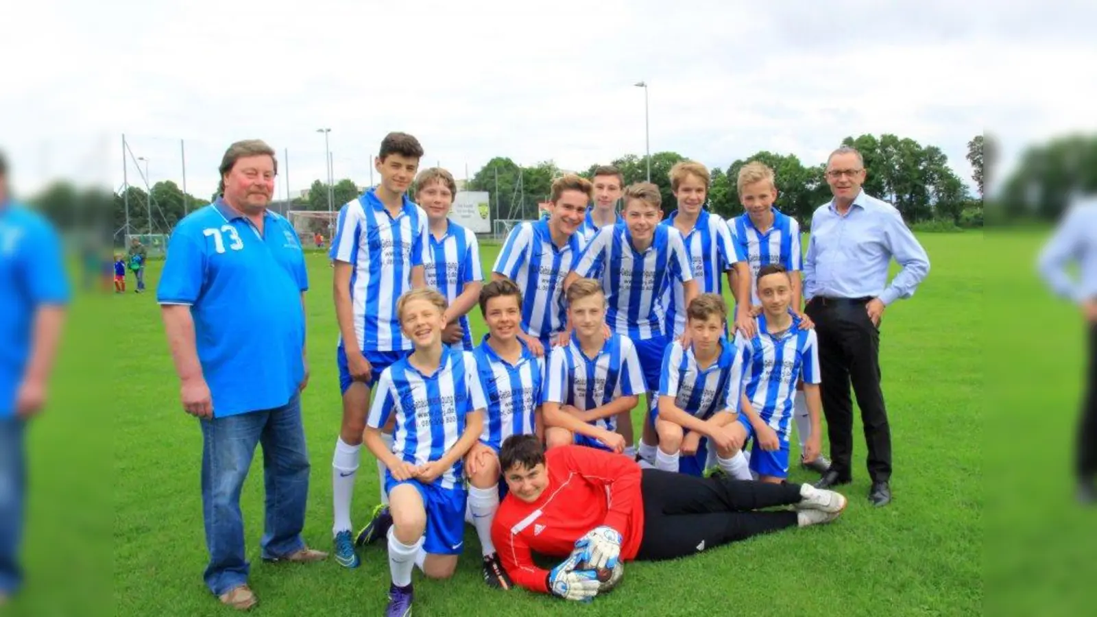 Erster Vorstand Manfred Schneider (l.) und zweiter Jugendleiter Niki Decke (r.) mit der aktuellen C-Jugend-Mannschaft, eine von 20 Jugendmannschaften des DJK. (Foto: us)