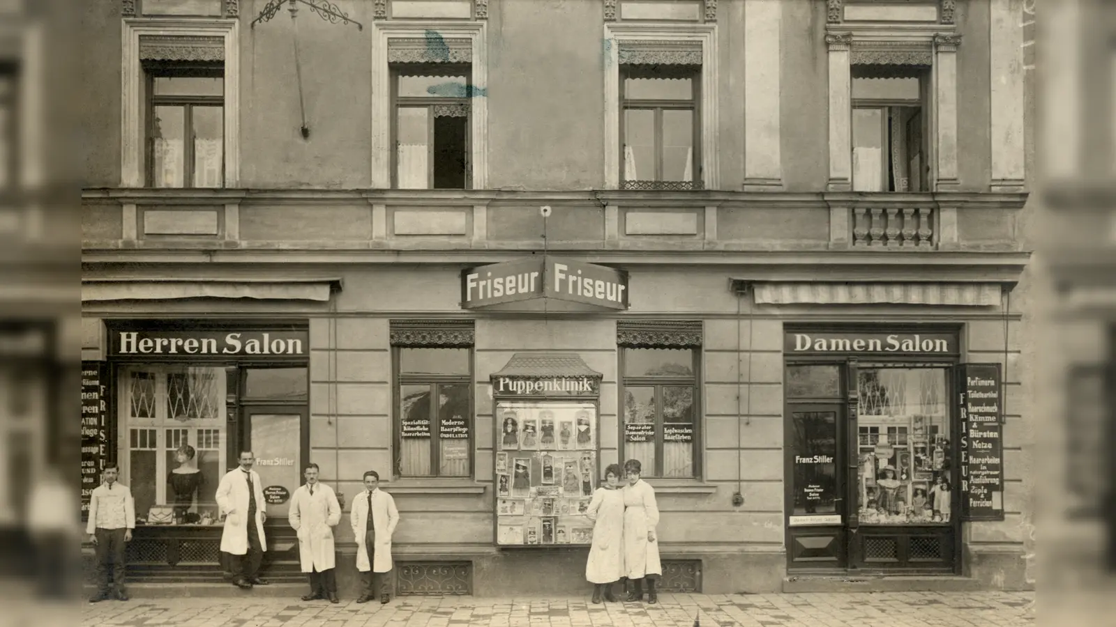 Im Geschäft des Damen- und Herrenfriseurs Stiller in der Kazmairstraße 10 gab es auch eine Puppenklinik (Mitte). Diese Aufnahme entstand 1920. (Foto: Stadtarchiv München DE-1992-FS-PK-STB-01700)