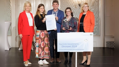 Der „Mobile Treffpunkt des Nachbarschaftstreffs” der Diakonie erhielt den Bayerischen Innovationspreis Ehrenamt. Ministerin Ulrike Scharf (l.) und Ehrenamtsbeauftragte Gabi Schmidt (r.) übergaben ihn an Jessica Vogel, Ralph Wiegand und Evangelia Kostopoulou (v.l.n.r.). (Foto: StMAS/ Nötel.)