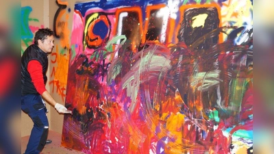 Daniel Eichin (l.) vor einem Gemälde, das verschiedene Gruppen expressiv  bemalt hatten. (Foto: Hartmann)