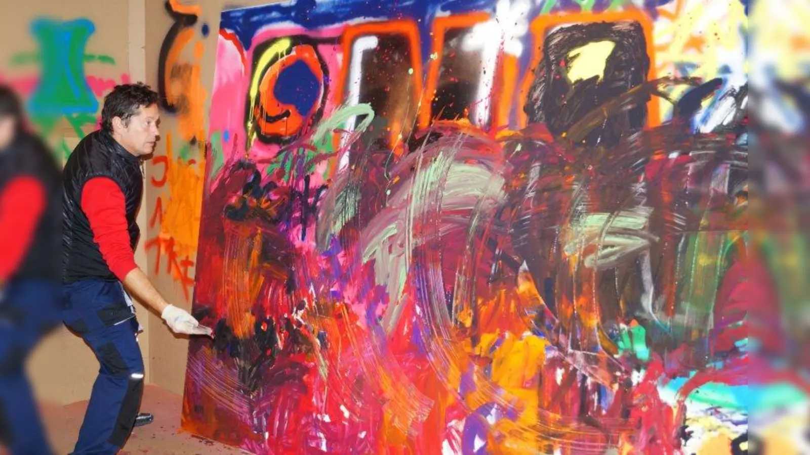 Daniel Eichin (l.) vor einem Gemälde, das verschiedene Gruppen expressiv  bemalt hatten. (Foto: Hartmann)