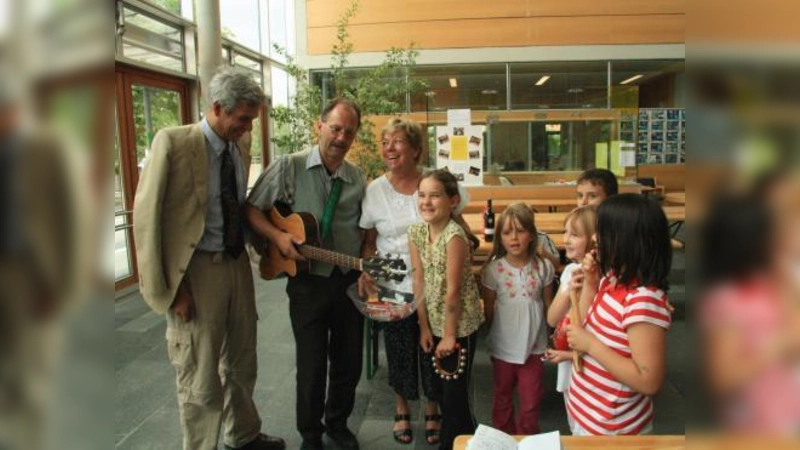 „Wir sind alle sehr, sehr traurig.“ Zum Abschied in den Ruhestand bekam die Martinsrieder Grundschulrektorin Christa Scholze ein Ständchen von den Flinken Flöhen. V.l. Thomas Roy, Thomas Schaffert, Christa Scholze und einige der Flinken Flöhe. (Foto: US)