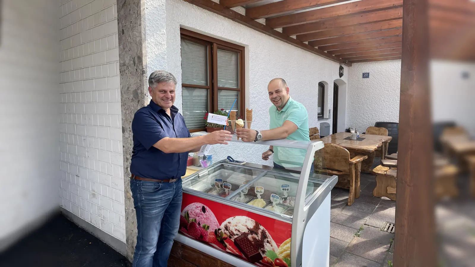 Auch der Bürgermeister kann der Kugel köstlichem Vanilleeis nicht widerstehen, die ihm Wirt Leo von der Starzelstuben reicht.<br> (Foto: Gemeinde Alling)