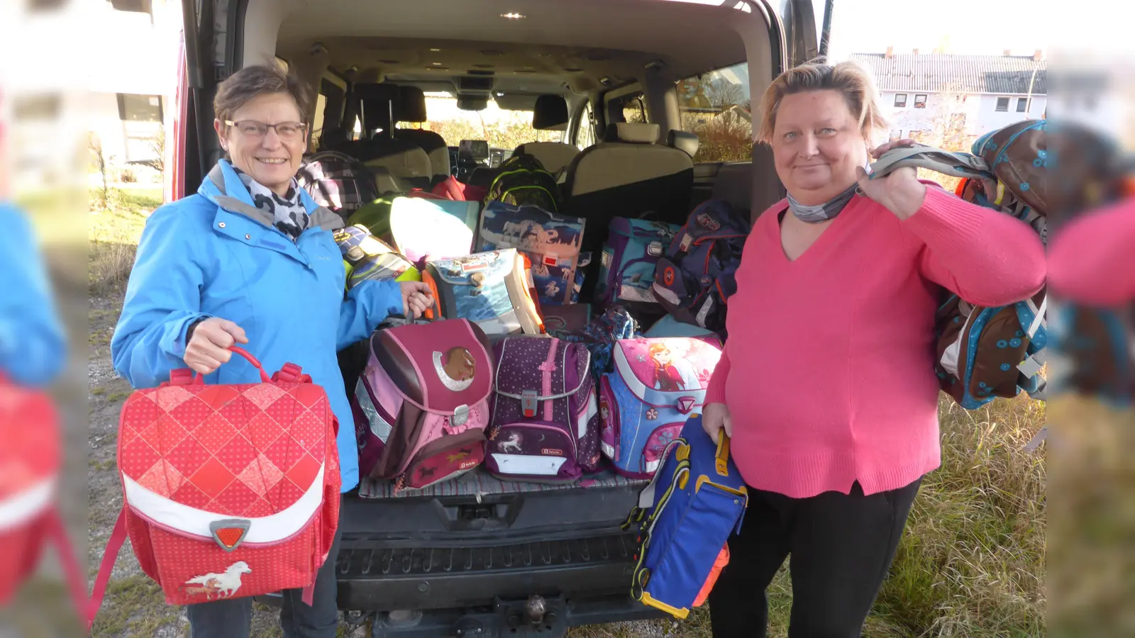 Maria Gallenberger (l.) übergibt die gesammelten Schultaschen an Petra Datkewitz-Reichert (r.), die die Schultaschen entsprechend weiterleitet.  (Foto: Gallenberger)