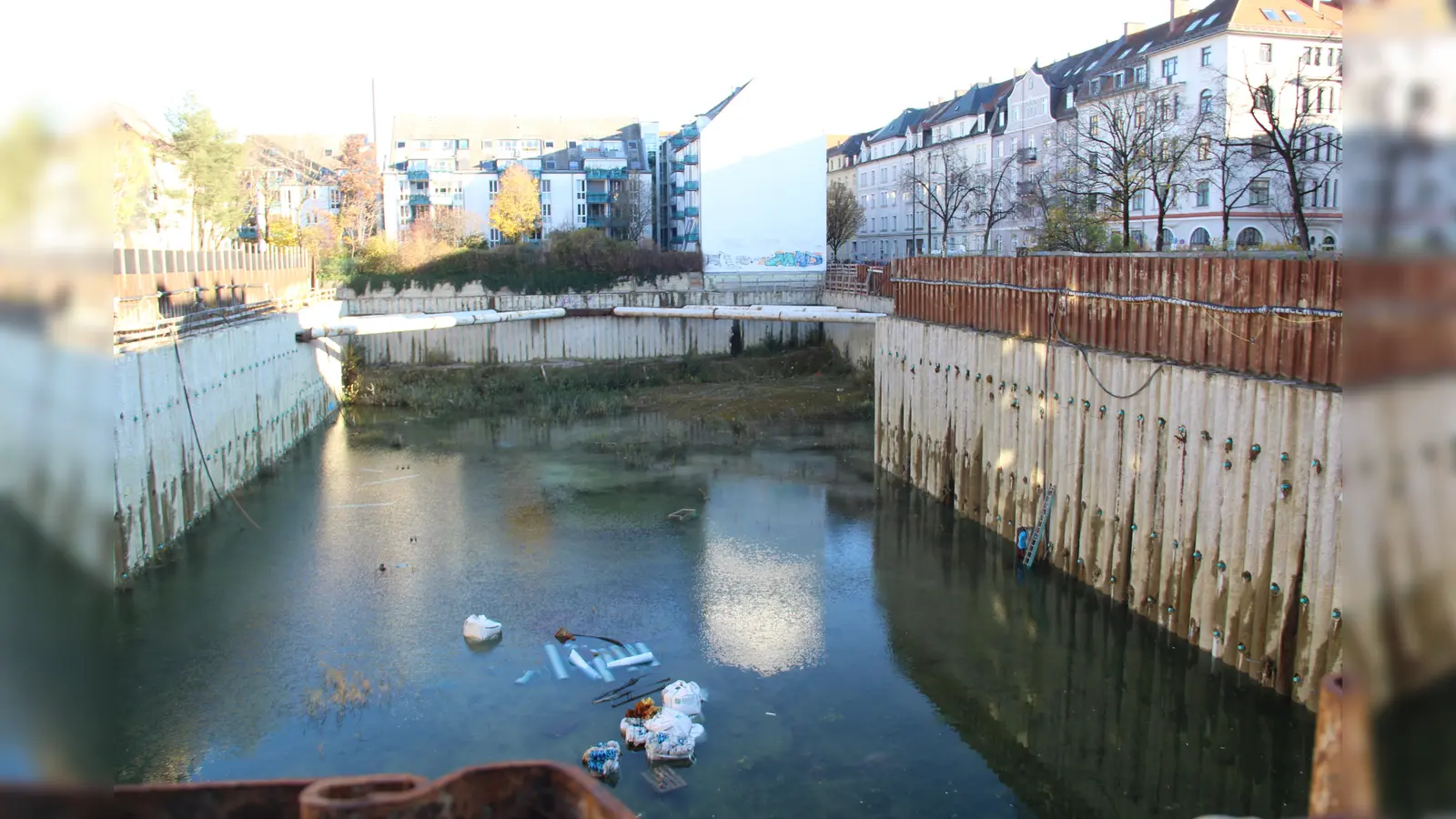 „Hier entstehen lichtdurchflutete Eigentumswohnungen mit hochwertiger Ausstattung”, behauptet ein großes Plakat am noch viel größeren Loch. (Foto: job)