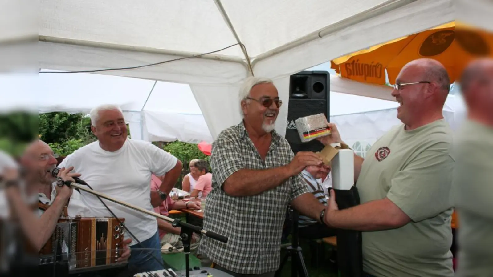 Welche Gaudi, als Dieter Lübbe, Vorsitzender des Kleingartenvereins SW 52, Stefan Mayer (rechts) eine halbe Million Euro in Schnippseln überreichte. Amüsierten sich „wie Bolle” (v.l.): „Toni“, die „kleinste Big-Band der Welt“ und Walter Korger, der „Vergnügungsvorstand” des Vereins. (Foto: tg)