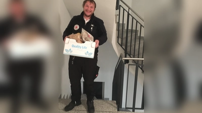 Die Tür bleibt zu: Andreas Szarzynski liefert Lebensmittel an einen Ismaninger in Quarantäne. (Foto: BRK)