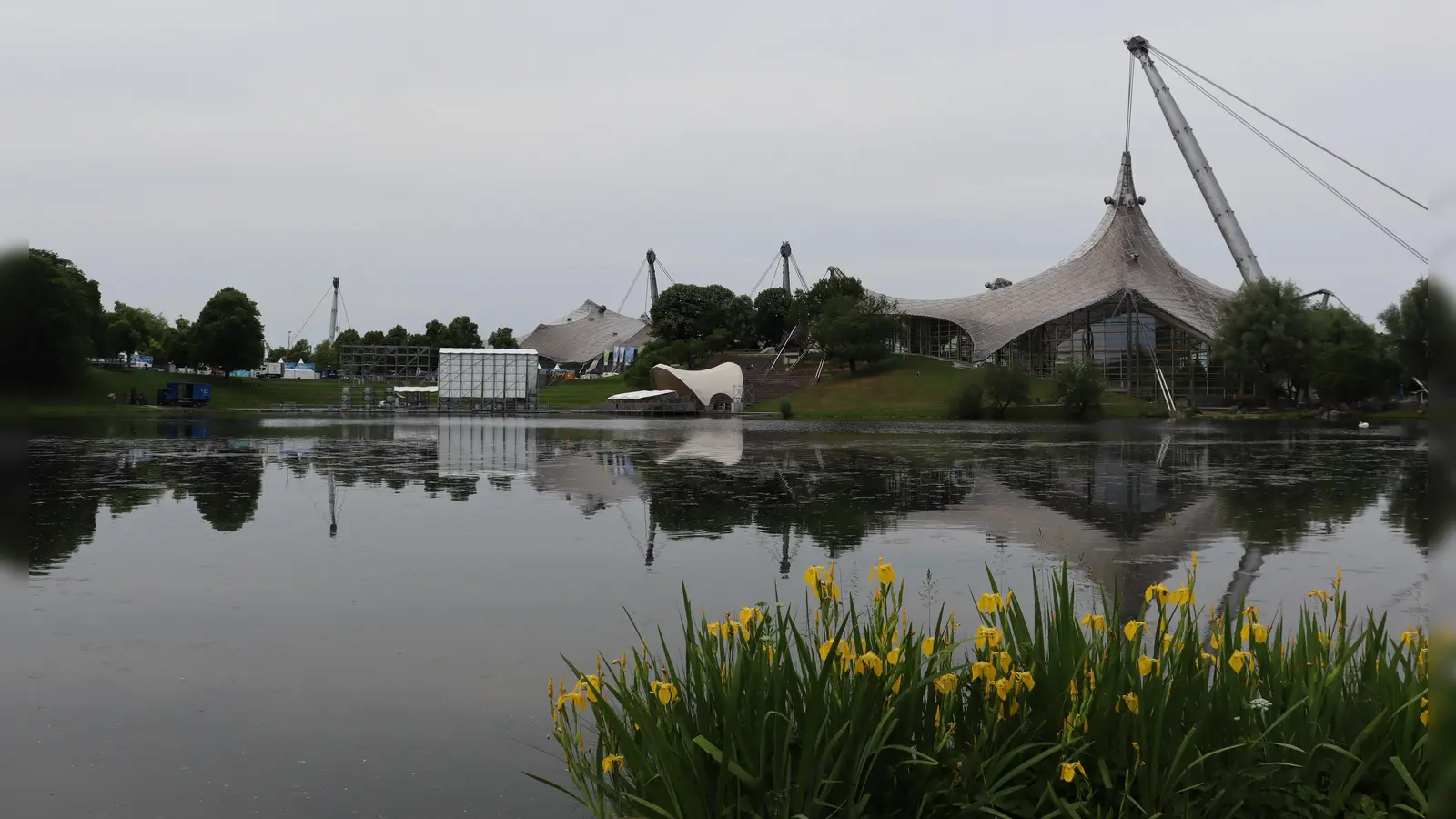 Was hier wie eine Kopfbedeckung aus der Biedermeierzeit hinter dem Olympiasee hervorragt, ist die Seebühne, auf der die Bands beim Theatron-Festival auftreten werden. (Foto: © mha)