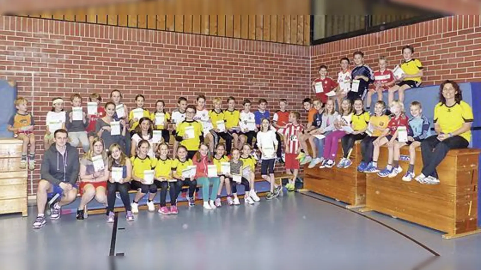 57 Leichtathletik-Kinder des TSV Grasbrunn halten stolz ihre Sportabzeichen in den Händen.	 (Foto: privat)