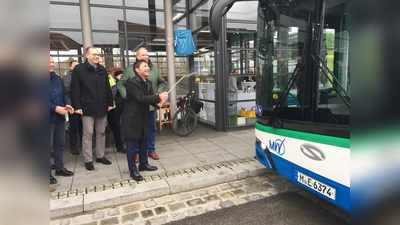 Unterföhrings Erster Bürgermeister Andreas Kemmelmeyer freut sich über die Inbetriebnahme der E-Buslinie 232 und weiht einen der Busse mit einer Sektdusche ein. (Foto: Landratsamt München)