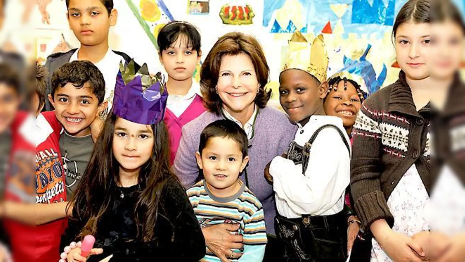 Königin Silvia im Kreis von Kindern, die sie in  München besucht hat.	 (Foto: Jens Rötzsch/Childhood)