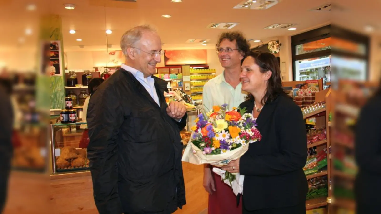 Anerkennung für die große Unterstützung: Robert Scheerer vom Gesundheitsforum überreichte Schirmherrin Theresa Schopper ein Dankeschön-Blumenstrauß. Im Hintergrund Peter Brunnhuber vom Pasinger Reformhaus. (Foto: US)