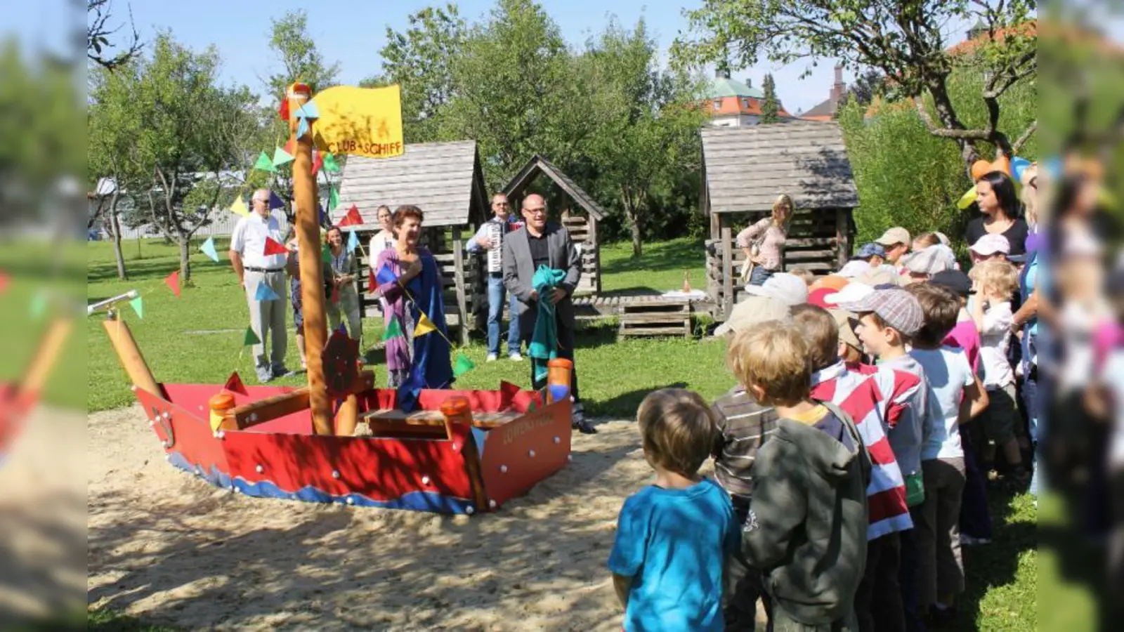 „Clubschiff Löwenstern“ heißt das neue Spielschiff im BRK Kindergarten. Bürgermeisterin Christine Borst und BRK-Vertreter Stefan Ronnsiek (Bildmitte) durften die Tücher von den verhüllten Namensschildern ziehen. (Foto: US)