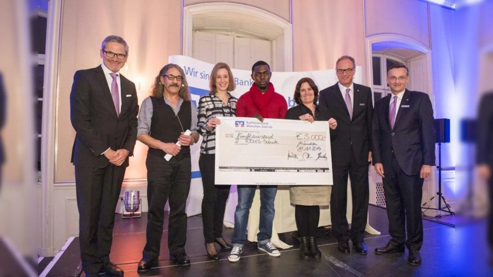 Die Vorstände der Raiffeisenbank München-Süd eG und die Vertreter der ISuS-Schule bei der Spendenübergabe (von links): Werner Nottensteiner (Bankvorstand), Reza Karimitari (ISuS), Anita Michalski (ISuS), Schüler, Miriam Herrmann (Schulleiterin), Heinz Schneider (Vorstandsvorsitzender der Raiffeisenbank), Reinhard Andres (Bankvorstand). (Foto: pi)