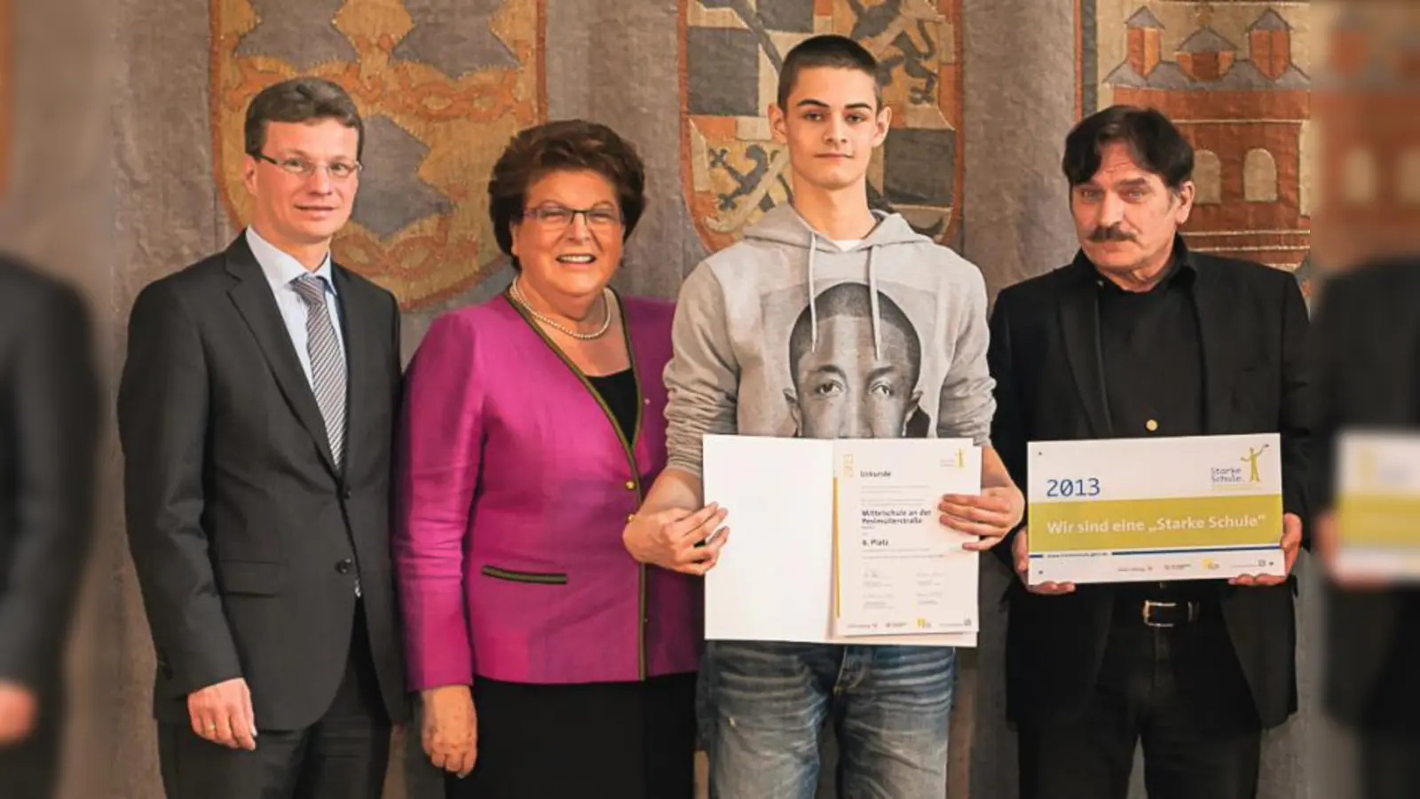 „Wahnsinnig stolz”. Rektor Rudolf Weiss (r.) und Schülersprecher Yannick Thomsen (2.v.r.) nehmen den Preis von Staatssekretär Bernd Sibler und Landtagspräsidentin Barbara Stamm entgegen. (Foto: pi)
