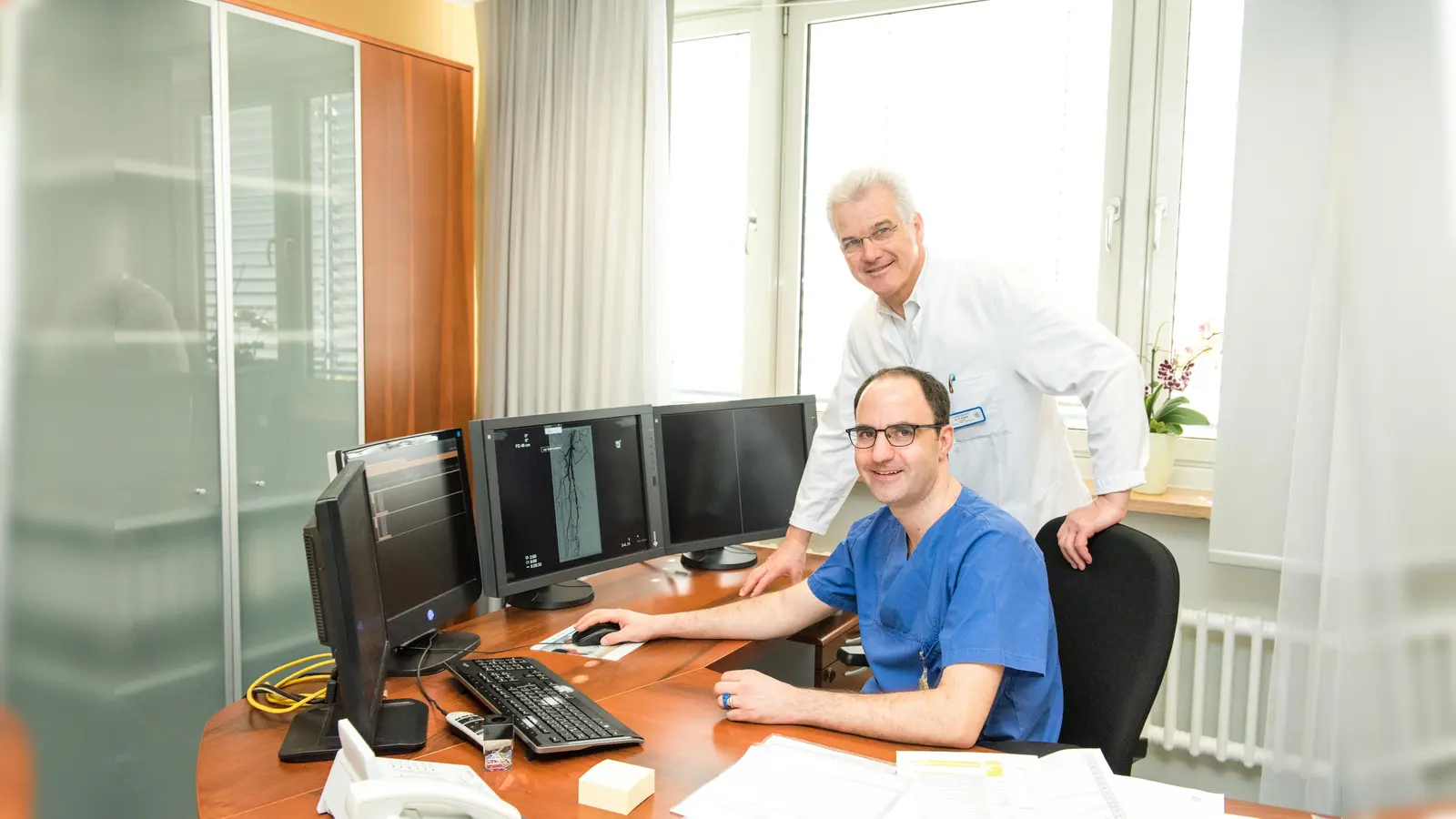 Bei Fallbesprechungen von Gefäßerkrankungen kommen die Kompetenzen des Gefäßchirurgen Dr. Peter Kreissl (stehend) und des Radiologen Dr. Marco Heinz zusammen. (Foto: Alexander Zettl)