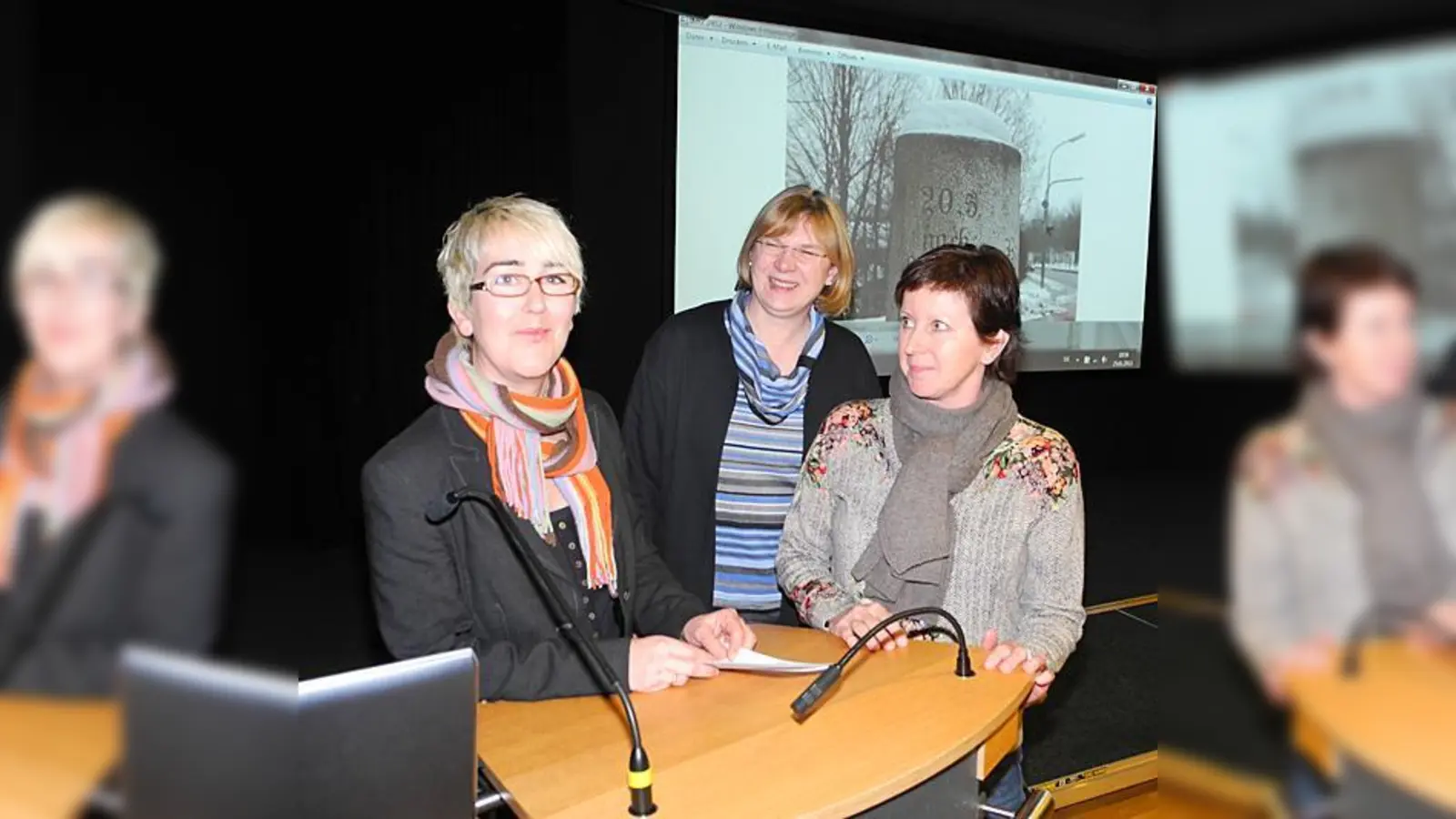 Ingrid Scharl, Christine Heinz und Doris Krinninger (von links) betreuen das Projekt »Ismaninger Hörpfad«. Im Hintergrund ein Foto einer der möglichen Stationen: der Kilometerstein am alten Fußballplatz.	 (Foto: Gabriele Heigl)