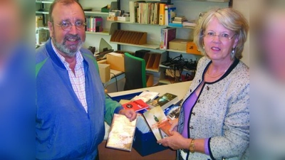 Stephanie Jacobi, die stellvertretende Elternbeiratsvorsitzende des Bertolt-Brecht-Gymnasiums, übergibt die Spende an Dr. Baumann, den Bibliotheksbeauftragten der Schule. (Foto: pi)