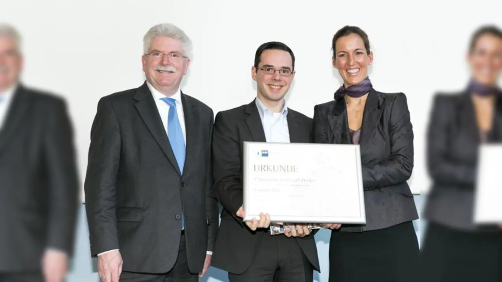 Christian Schraufstetter (Mitte) bekommt seine Urkunde für das beste Prüfungsergebnis.	 (Foto: IHK)