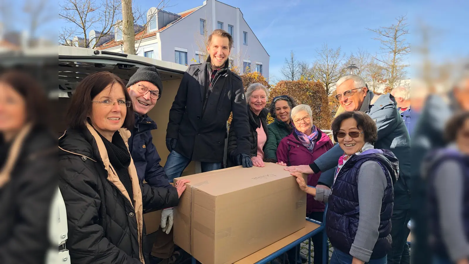 Die Ankunft des Lieferwagens in Neufahrn und ein Team der Kleiderkammer, das beim Ausladen hilft. (Foto: VA)