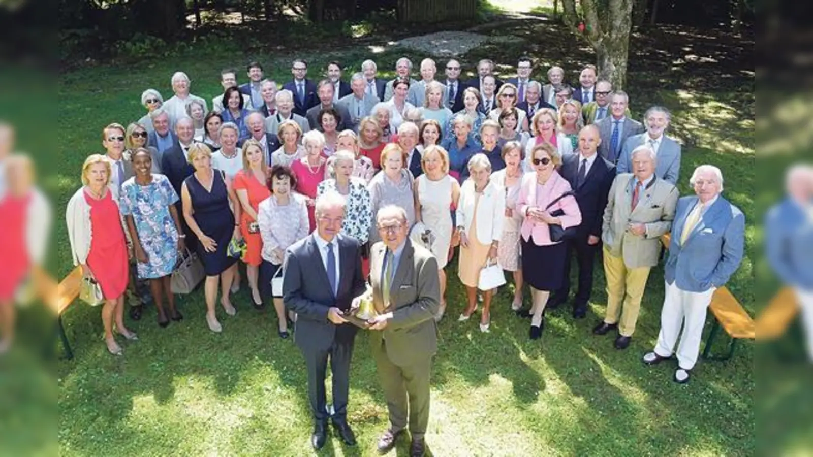 Thomas Schwartz (rechts) überreicht die rotarische Glocke an seinen Nachfolger Volker Gerlach, umringt von den Mitgliedern des RCG mit ihren Partnerinnen bei der Ämterübergabe 2018 im Waldhaus zur alten Tram in Straßlach.	 (Foto: RCG)