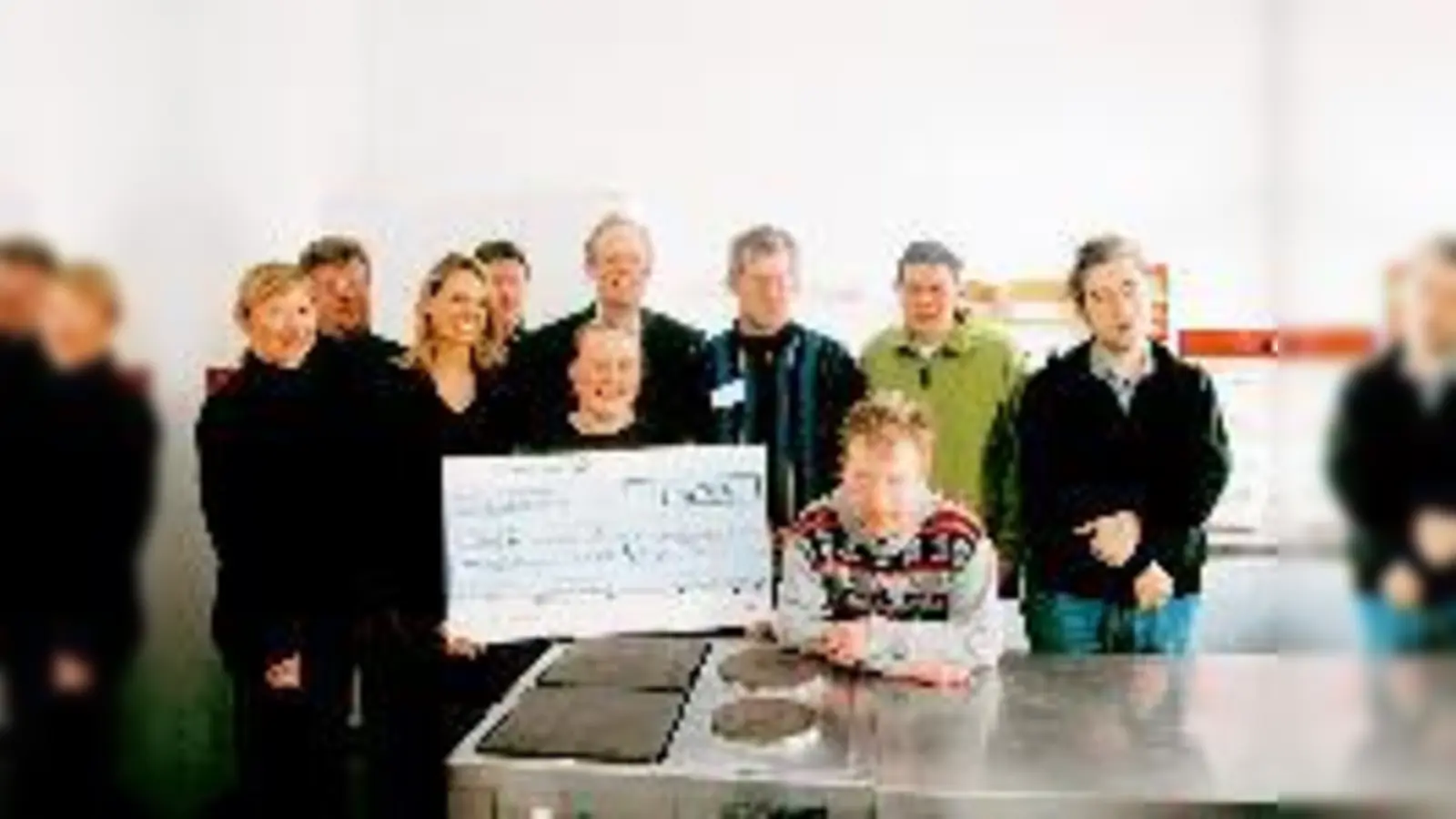 Kochkursleiterin Eva Bernlochner (mit Scheck) vom HPCA nahm vergangenen Donnerstag eine Spende des Pharmaunternehmens Organon entgegen. Von dem Geld wird ein neuer Herd angeschafft.	 (Foto: M. Sax)