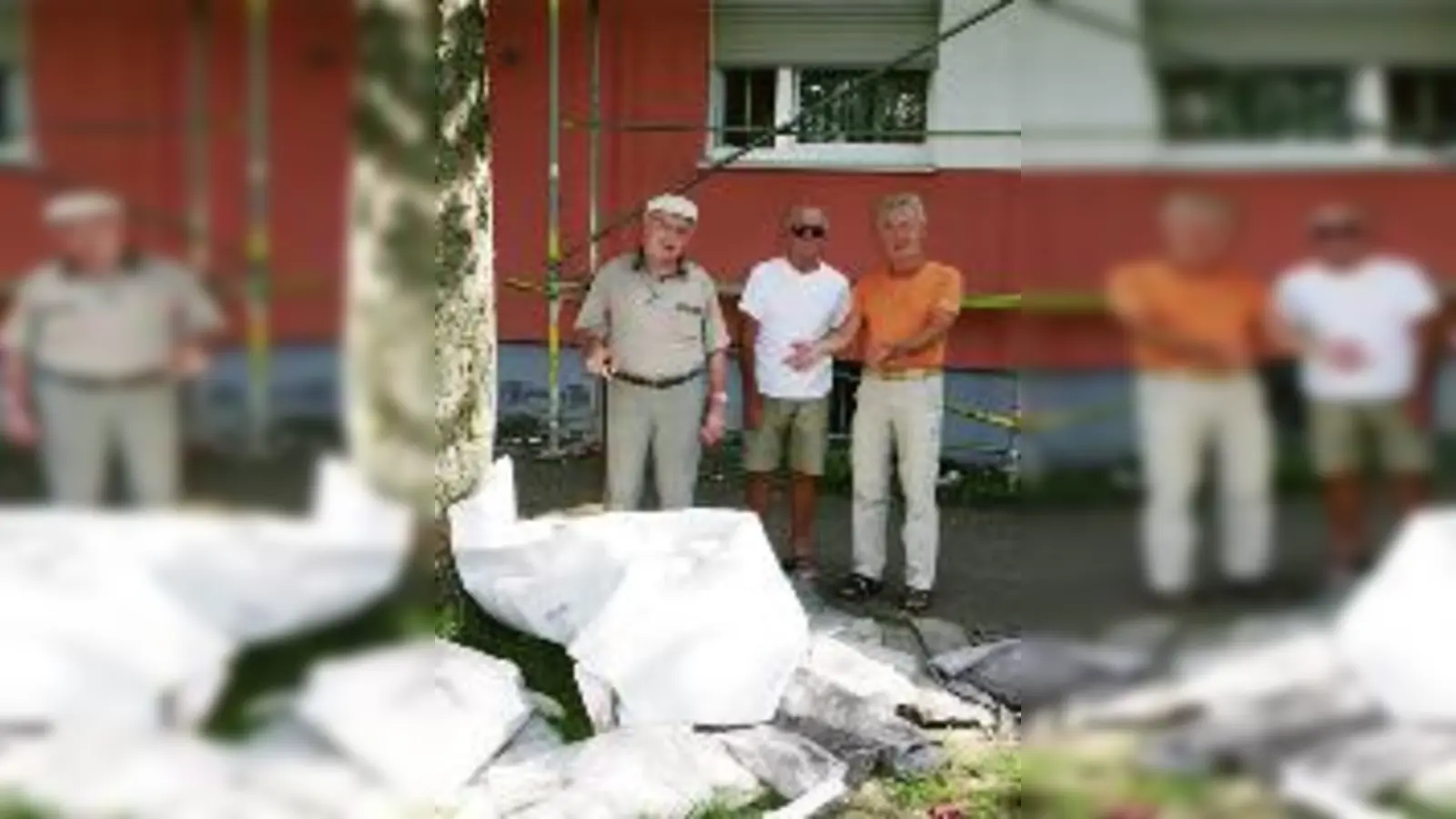 »Lauingerstraßler« Jakob Liebl, Theodor Schuster und Hans Kramer, Mitglied des Bezirksausschusses Moosach, vor der Abdeckfolie, die für dunkle Räume gesorgt hatte und nun im Hof herumliegt. 	 (Foto: wei)