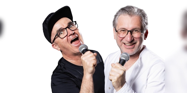 Uli Wurschy (l.) und Volker Becker stehen am 21. Oktober in der Halle E im Gasteig HP8 auf der Bühne und moderieren das Rudelsingen. (Foto: Joachim Pantel)