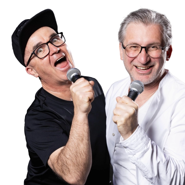 Uli Wurschy (l.) und Volker Becker stehen am 21. Oktober in der Halle E im Gasteig HP8 auf der Bühne und moderieren das Rudelsingen. (Foto: Joachim Pantel)