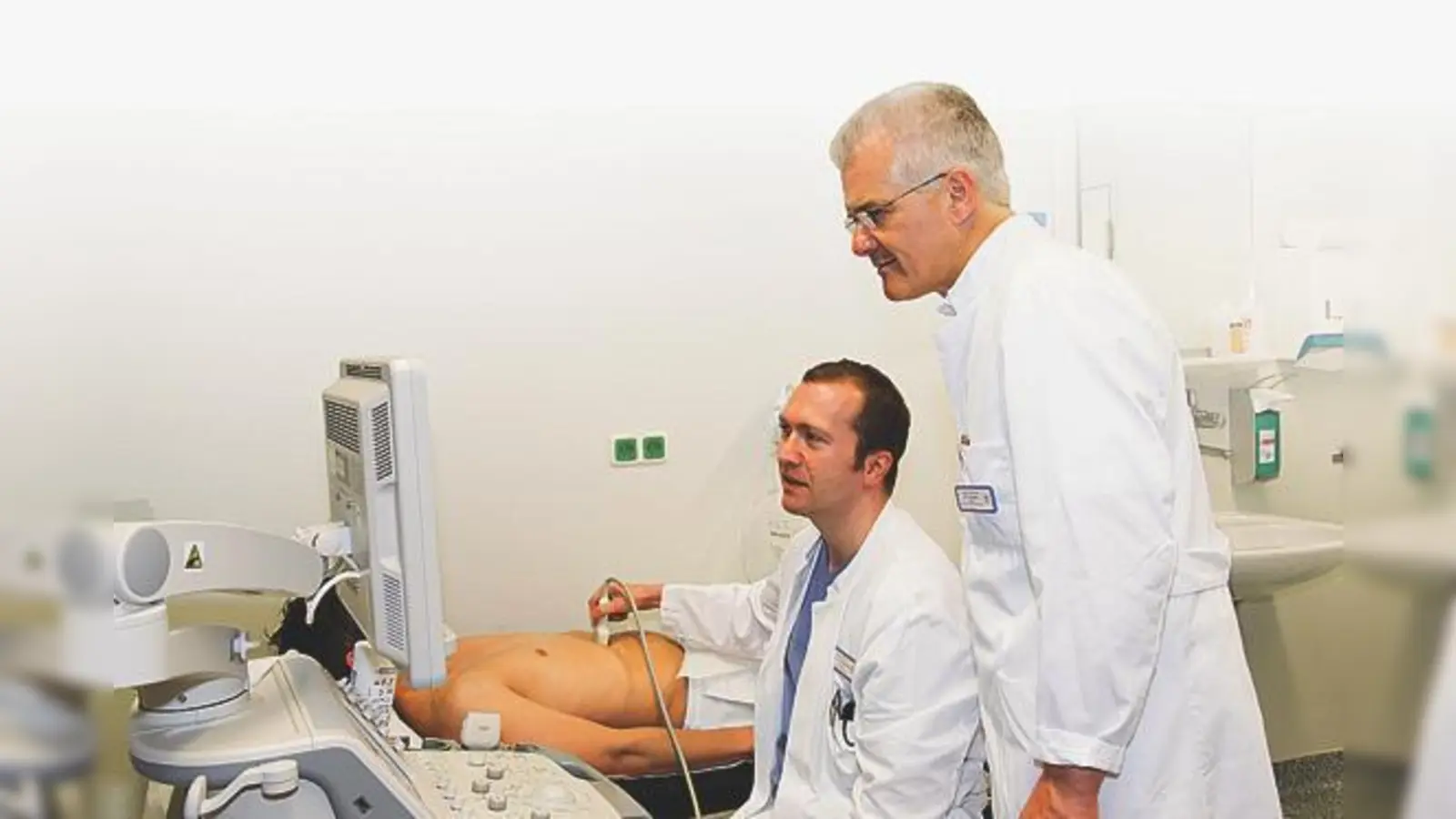 Dr. Thomas Nicolaus und Dr. Peter Kreissl (v. li.) untersuchen einen Patienten mit  Oberbauchschmerzen.	 (Foto: kk)