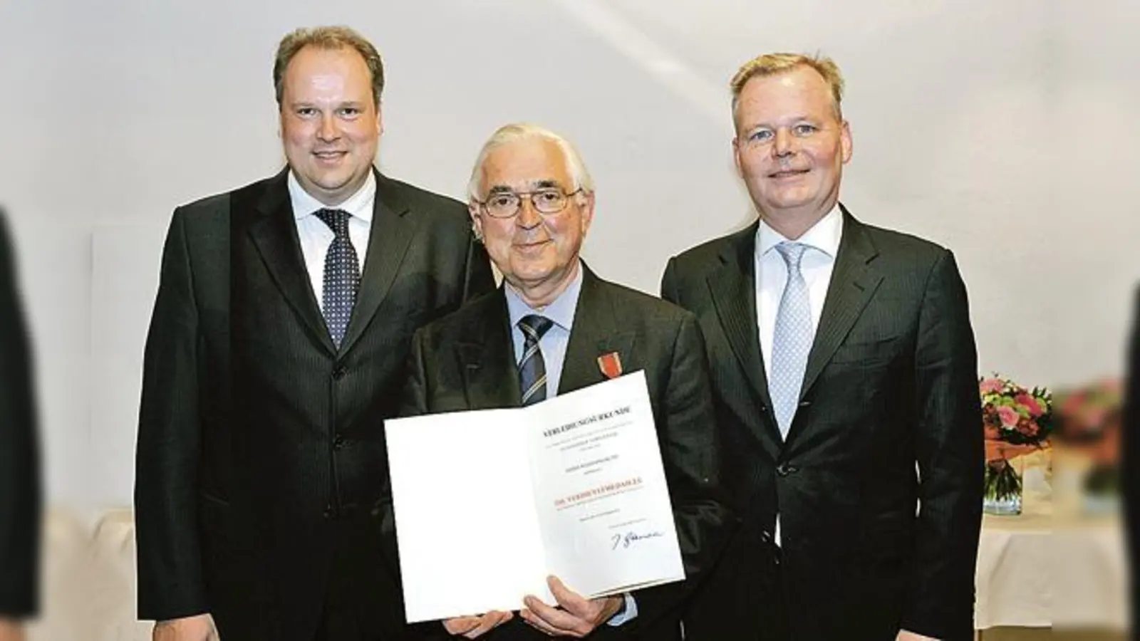 Landrat Christoph Göbel, Wolfgang Kuny und Bürgermeister Jan Neusiedl (v. l.) bei der Übergabe der Bundesverdienstmedaille.	 (Foto: VA)