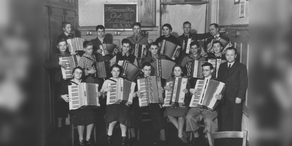 Ein Vereinsfoto von 1938 zeigt den damaligen Handharmonika-Club Neuhausen mit vielen jungen Mitgliedern. Die Tafel im Hintergrund trägt die Aufschrift „Harmonika Club Neuhausen, 10.3.38“. (Foto: Akkordeonorchester München e.V.)