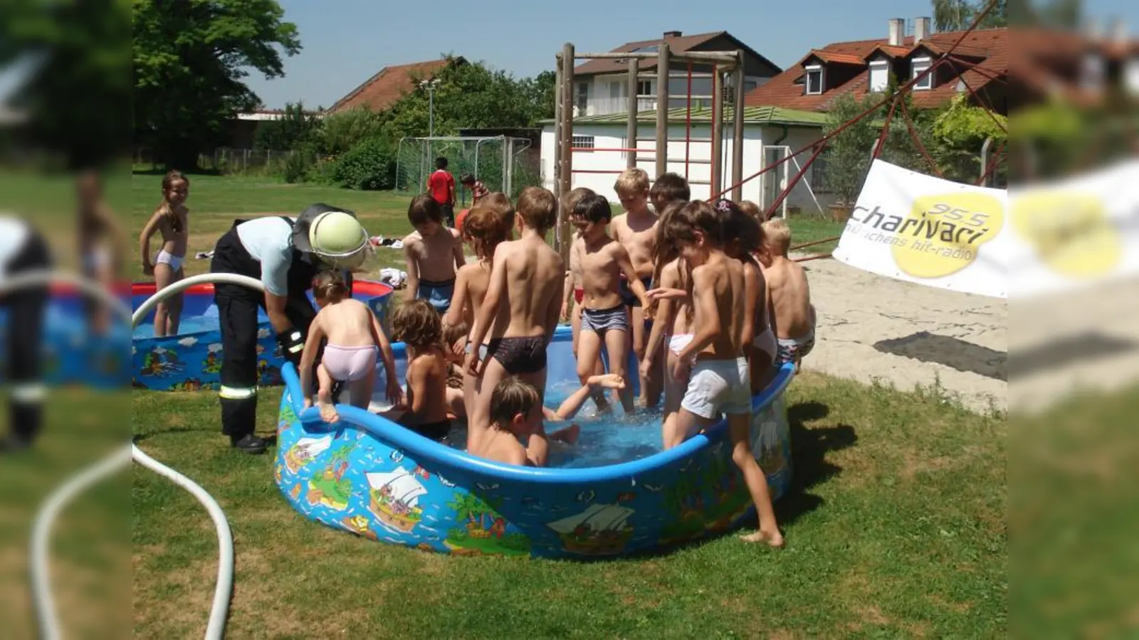 Von Radio Charivari und der Freiwilligen Feuerwehr Ismaning hat die Mittagsbetreuung FLEMIGO kurz vor den Schulferien Besuch bekommen – zur Freude der Kinder wurde dabei die Pausenwiese der Gotzmannschule kurzerhand in einen Wasserspielplatz verwandelt. (Foto: pi)