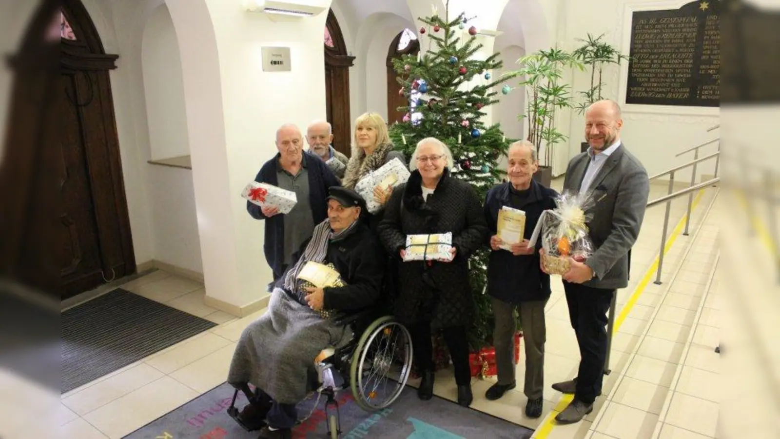 Symbolische Geschenkübergabe: Christian Lüttin (rechts), Geschäftsführer der Galeria Kaufhof am Rotkreuzplatz, und Seniorenbeirätin Ingeborg Staudenmeyer (2. von rechts) zusammen mit Altenpflegerin Sabine Herbrich und Bewohnern des Altenheims Heilig Geist. (Foto: sb)