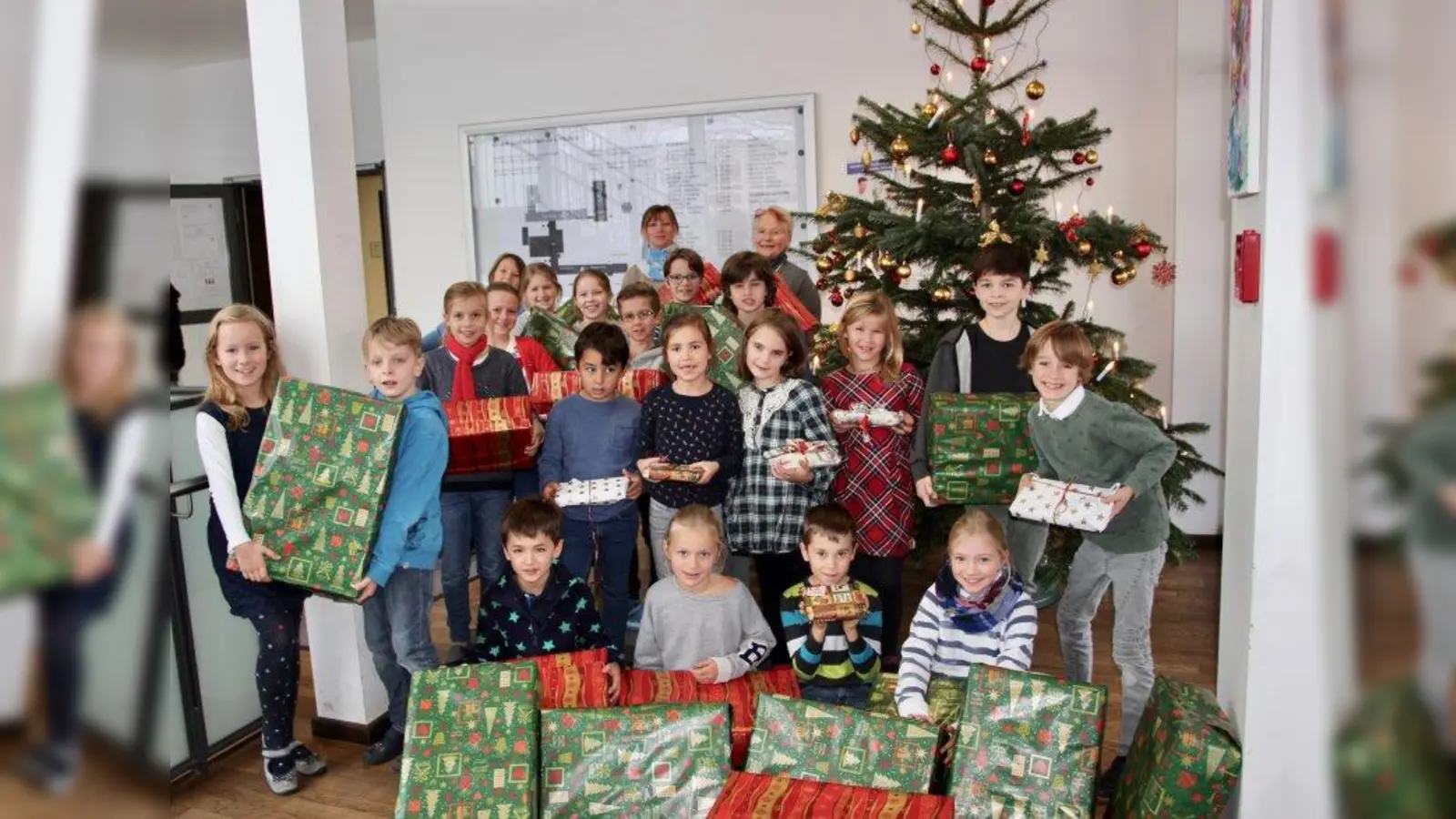 Leckere und nützliche Sachen für Senioren im Würmtal: Die Kinder der Grundschule Lochham haben in der vergangenen Woche viele Päckchen gepackt. Elfi Kalkühler vom Verein Martinsrieder Christkindlmarkt e.V. (hinten rechts, daneben Elternbeiratsvorsitzende Sabine Stiegler-Nardi) dankte den Kindern dafür. (Foto: us)