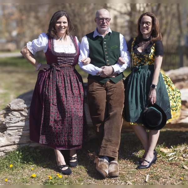Mitarbeiterinnen und ein Mitarbeiter der aktion hoffnung präsentieren Trachtenoutfits, die beim Markt angeboten werden. (Foto:  Marie Kracker, aktion hoffnung)