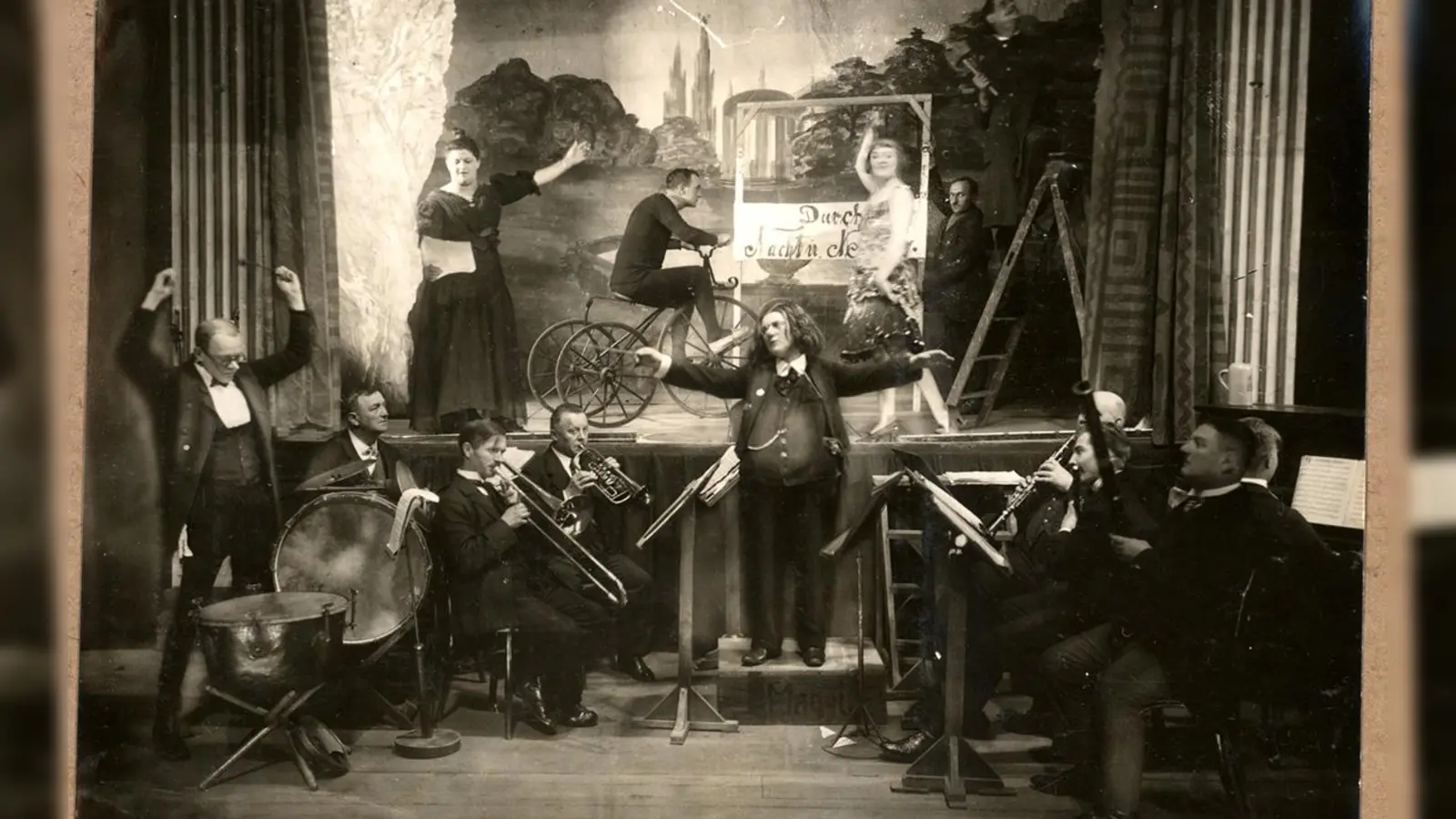 Karl Strauß als “Phänomen auf dem Dreirad” fährt “Durch Nacht und Nebel”, Karl Valentin haut dazu auf die Pauke und Liesl Karlstadt dirigiert. (Bild aus dem Jahr 1923) (Foto: © Valentin-Karlstadt-Musäum)