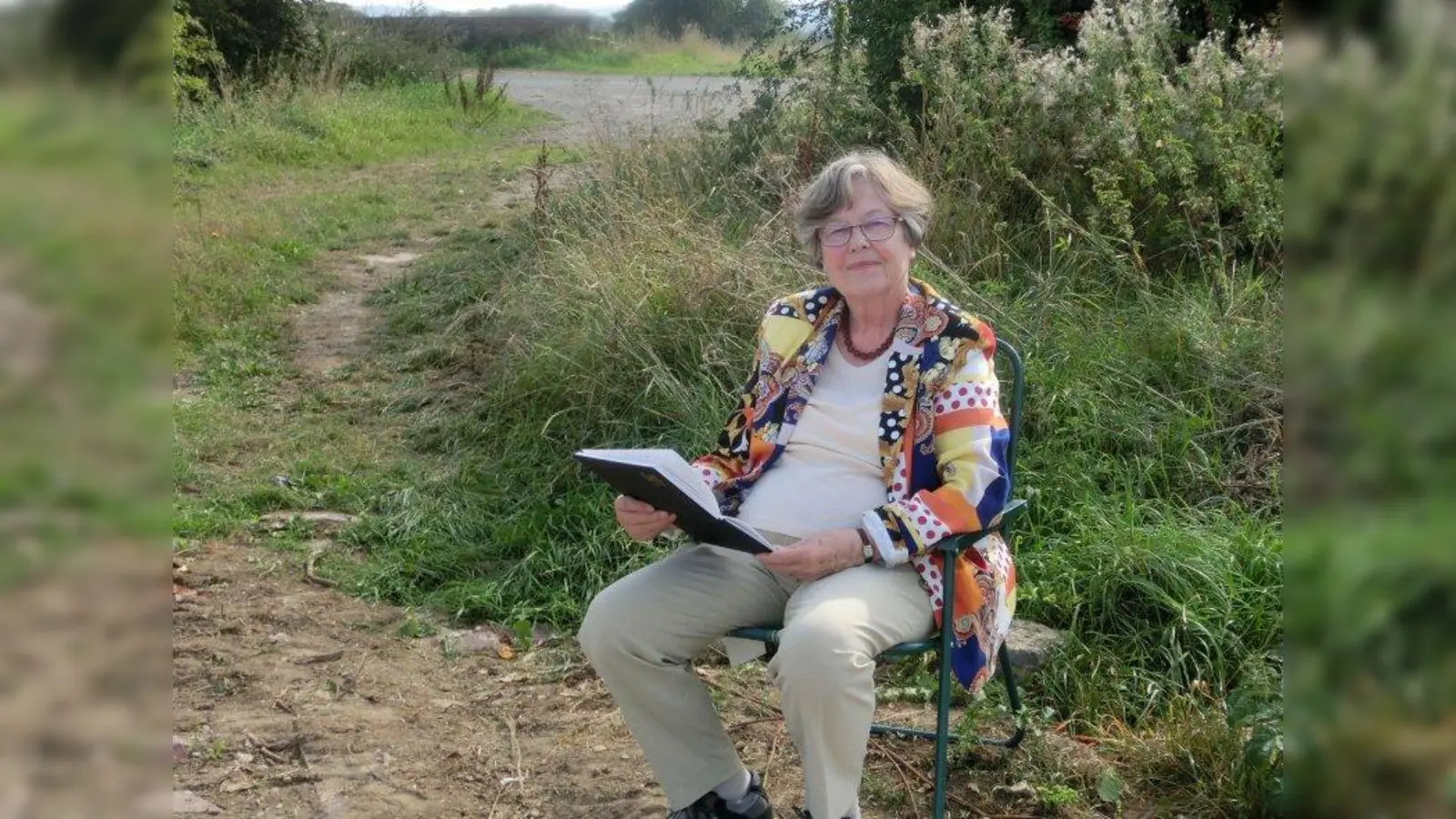 Angela Musil mit einem Skizzenbuch in der Landschaft von Kent (England). „Meine Aufmerksamkeit gilt der Landschaft, die noch Spuren der unverdorbenen Natur aufweist”, sagt sie. (Foto: Bernard Winchester)