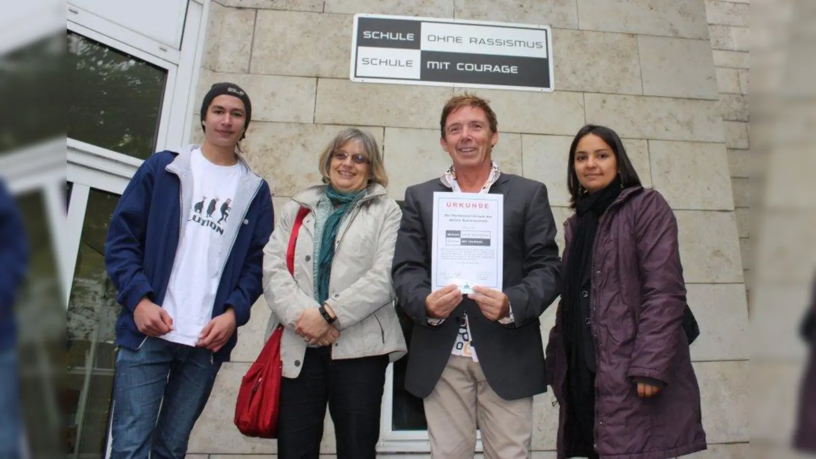 Schulleiter Heribert Riedhammer hält stolz die Urkunde zur „Schule gegen Rassismus”. Mit ihm freuen sich: Schüler Alex (links), Martina Löschberger und Dr. Suzan Kozak (rechts). (Foto: Hö)