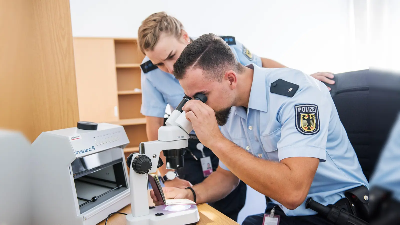Bundespolizisten prüfen einen Pass auf seine Echtheit (Symbolbild). (Foto: BuPol)